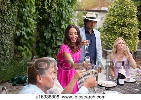 Stock Photography - Guests enjoying and celebrating at garden party. Fotosearch