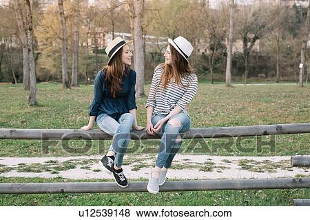 Stock Photo - Happy girlfriends in park. Fotosearch
