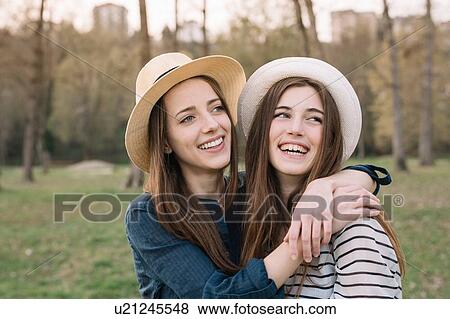 Stock Photo - Happy girlfriends in park. Fotosearch