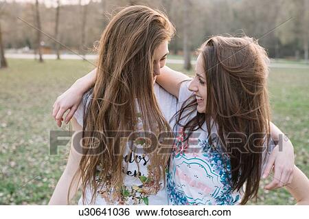 Stock Photograph - Happy girlfriends in park. Fotosearch