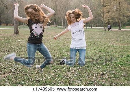 Happy girlfriends jumping for joy in park View Large Photo Image Stock Photography - Happy girlfriends jumping for joy in park. Fotosearch