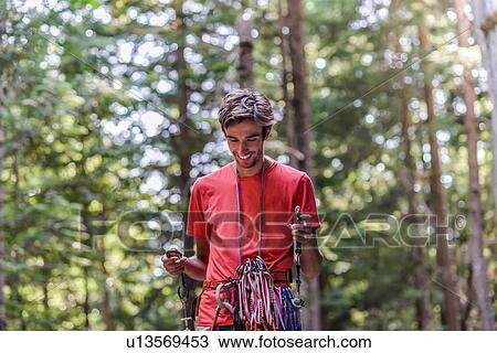 Stock Image - Happy rock climber in forest. Fotosearch