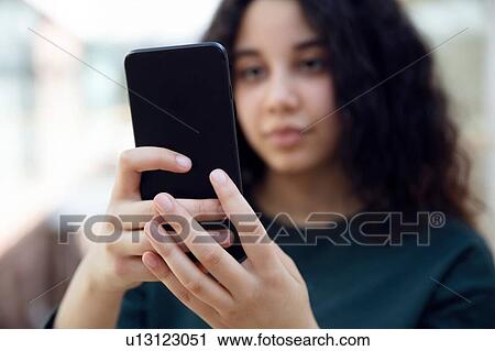 High school girl in school corridor looking at smartphone View Large Photo Image Stock Image - High school girl in school corridor looking at smartphone. Fotosearch