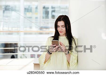 High school girl in school lobby looking at smartphone View Large Photo Image Stock Image - High school girl in school lobby looking at smartphone. Fotosearch