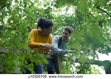 Hiker couple looking over wooden bridge View Large Photo Image Stock Photo - Hiker couple looking over wooden bridge. Fotosearch