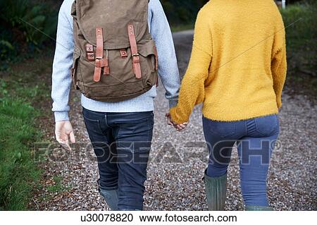 Stock Image - Hiker couple walking in countryside. Fotosearch