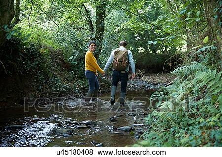 Hiker couple walking in stream View Large Photo Image Stock Photo - Hiker couple walking in stream. Fotosearch