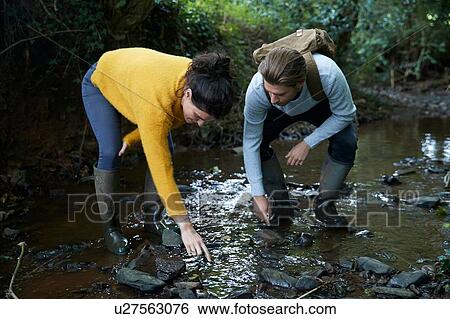 Hiker couple walking in stream View Large Photo Image Stock Photograph - Hiker couple walking in stream. Fotosearch