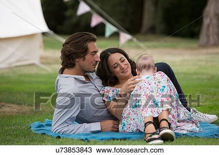 Husband and wife with baby in garden View Large Photo Image Stock Image - Husband and wife with baby in garden. Fotosearch