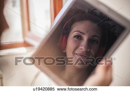 Image of woman's face with headphones on digital tablet View Large Photo Image Stock Photography - Image of woman's face with headphones on digital tablet. Fotosearch