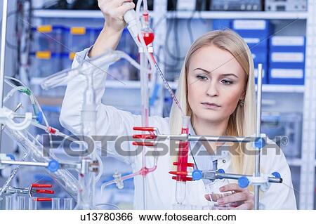 Stock Photograph - Laboratory assistant with chemical experiment.. Fotosearch