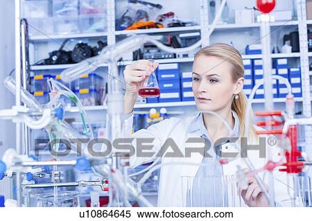 Stock Photography - Laboratory assistant with chemical experiment.. Fotosearch