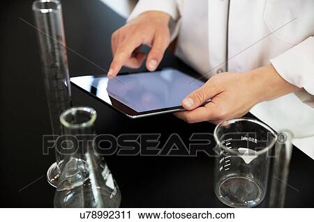 Stock Image - Laboratory worker using digital tablet. Fotosearch