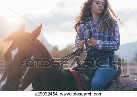 Picture - Long haired young woman on horseback, Primaluna, Trentino-Alto Adige, Italy. Fotosearch