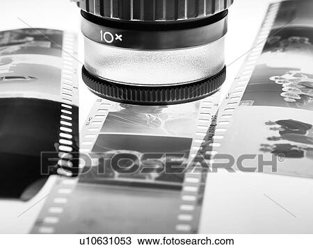Stock Image - Loupe over film negatives. Fotosearch