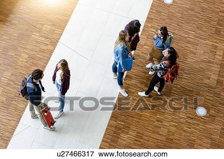 Male and female university students chatting in university lobby, high angle view View Large Photo Image Stock Photo - Male and female university students chatting in university lobby, high angle view. Fotosearch