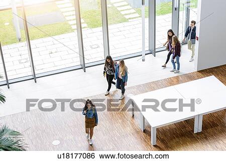 Stock Photograph - Male and female university students arriving in university lobby, high angle view. Fotosearch