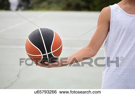 Male teenage basketball player holding ball on basketball court, cropped View Large Photo Image Stock Photograph - Male teenage basketball player holding ball on basketball court, cropped. Fotosearch