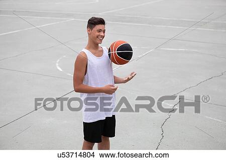 Male teenage basketball player on basketball court throwing and catching ball View Large Photo Image Picture - Male teenage basketball player on basketball court throwing and catching ball. Fotosearch