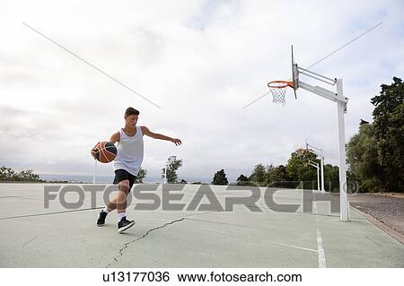 Male teenage basketball player running with ball on basketball court View Large Photo Image Stock Photograph - Male teenage basketball player running with ball on basketball court. Fotosearch