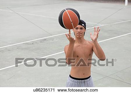 Male teenage basketball player spinning ball on finger on basketball court View Large Photo Image Stock Image - Male teenage basketball player spinning ball on finger on basketball court. Fotosearch