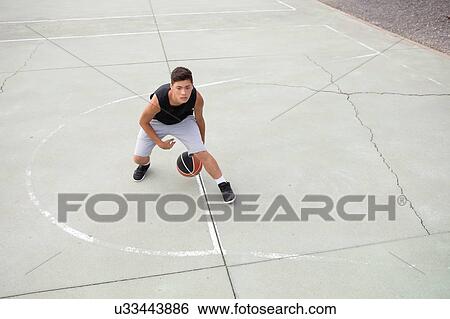 Male teenage basketball player practicing on basketball court, high angle view View Large Photo Image Stock Photograph - Male teenage basketball player practicing on basketball court, high angle view. Fotosearch