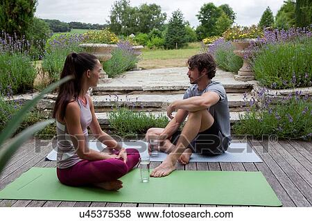 Man and woman practicing yoga in garden, taking a break on patio View Large Photo Image Stock Photo - Man and woman practicing yoga in garden, taking a break on patio. Fotosearch
