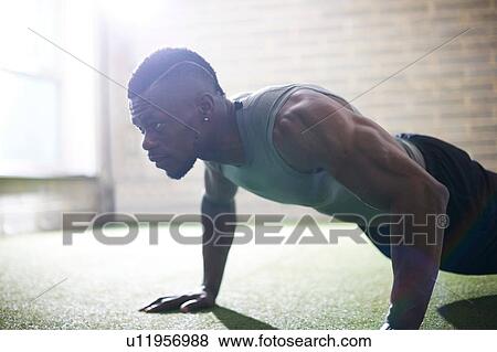 Stock Photo - Man doing plank in gym. Fotosearch