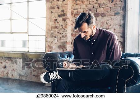 Man in armchair writing notes View Large Photo Image Picture - Man in armchair writing notes. Fotosearch