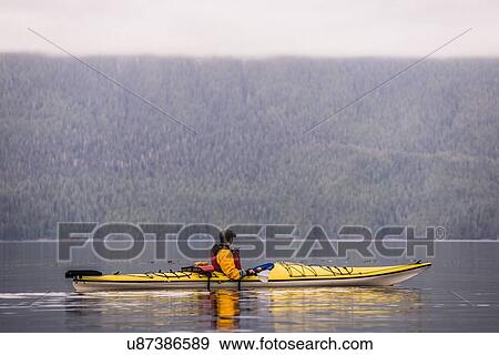 Stock Photo - Man kayaking in lake, Johnstone Strait, Telegraph Cove, Canada. Fotosearch