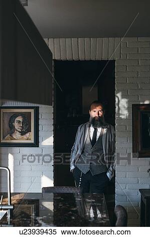 Stock Photography - Man leaning against doorway of kitchen. Fotosearch