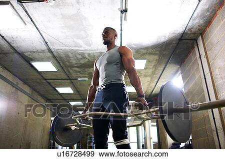 Man lifting barbell in gym View Large Photo Image Stock Photo - Man lifting barbell in gym. Fotosearch