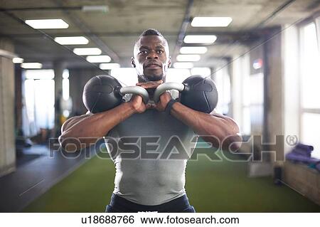 Man lifting kettlebells in gym View Large Photo Image Stock Photograph - Man lifting kettlebells in gym. Fotosearch