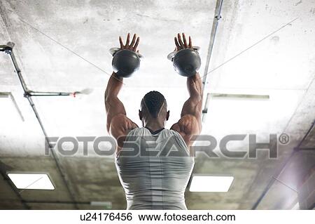 Man lifting kettlebells in gym View Large Photo Image Stock Photograph - Man lifting kettlebells in gym. Fotosearch