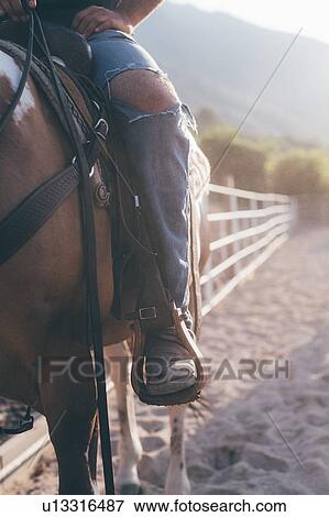 Man on horseback in rural equestrian arena, cropped View Large Photo Image Stock Photo - Man on horseback in rural equestrian arena, cropped. Fotosearch