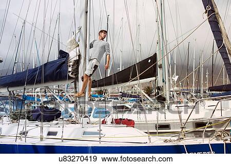 Stock Photo - Man on sailboat, Cape Town, Western Cape, South Africa. Fotosearch