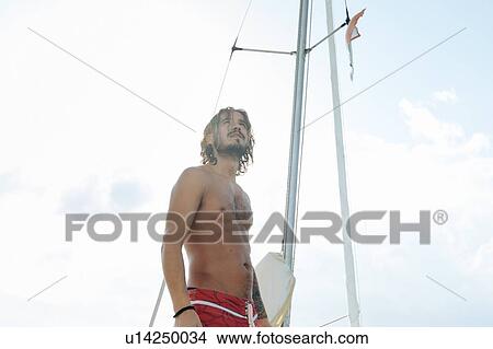 Picture - Man on sailboat. Fotosearch