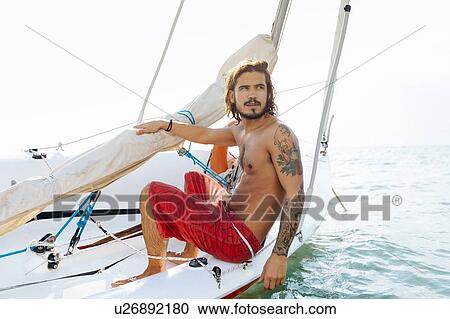 Man on sailboat View Large Photo Image Stock Image - Man on sailboat. Fotosearch