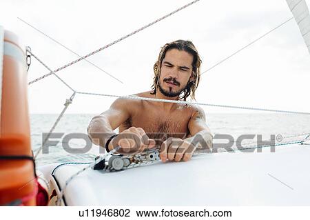 Man preparing sailboat View Large Photo Image Stock Image - Man preparing sailboat. Fotosearch