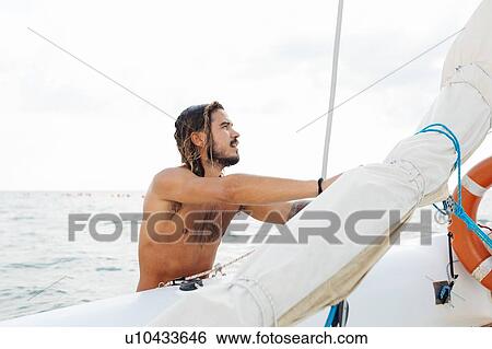 Stock Photograph - Man preparing sailboat. Fotosearch