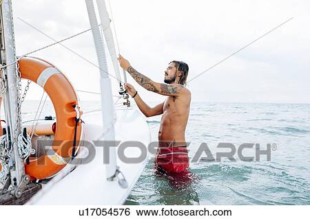 Man preparing sailboat View Large Photo Image Stock Photograph - Man preparing sailboat. Fotosearch