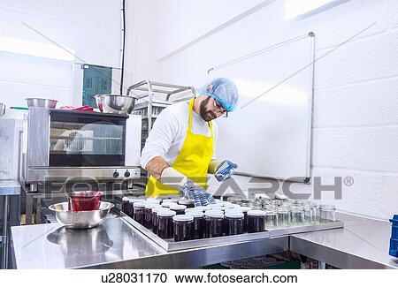 Man putting lids onto fresh jars of jam in industrial kitchen View Large Photo Image Stock Image - Man putting lids onto fresh jars of jam in industrial kitchen. Fotosearch