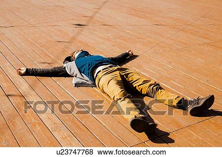 Stock Photo - Man relaxing on wooden decking. Fotosearch