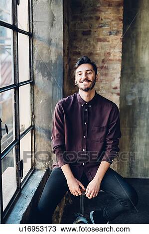 Man sitting on swivel stool by window View Large Photo Image Stock Image - Man sitting on swivel stool by window. Fotosearch