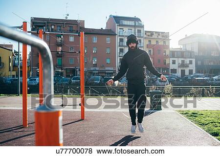 Stock Photo - Man skipping in outdoor gym. Fotosearch