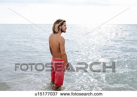 Stock Photo - Man standing in sea. Fotosearch