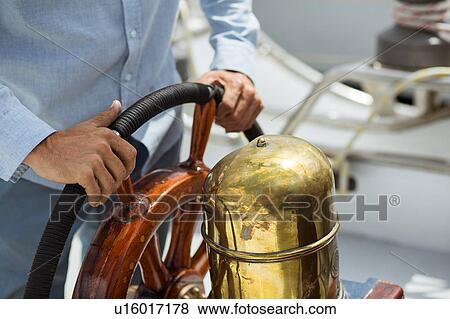 Man steering sailboat View Large Photo Image Stock Photo - Man steering sailboat. Fotosearch