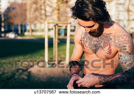 Stock Photo - Man taking break in outdoor gym. Fotosearch