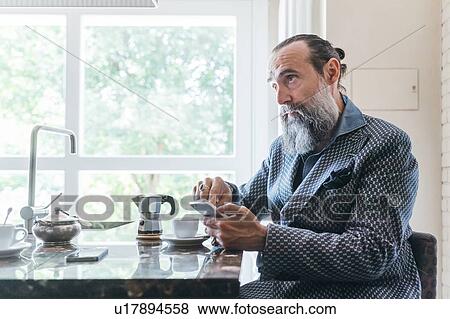 Man texting over coffee in kitchen View Large Photo Image Stock Photo - Man texting over coffee in kitchen. Fotosearch