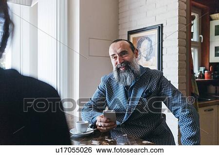 Man using cellphone and talking to friend in kitchen View Large Photo Image Stock Photograph - Man using cellphone and talking to friend in kitchen. Fotosearch